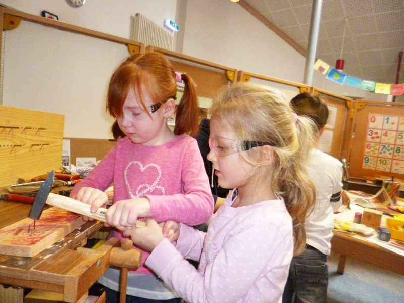 Mädchen hämmern Nägel ins Holz