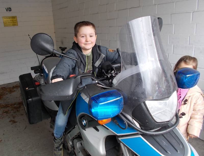 Kind sitzt auf einem Polizei-Motorrad