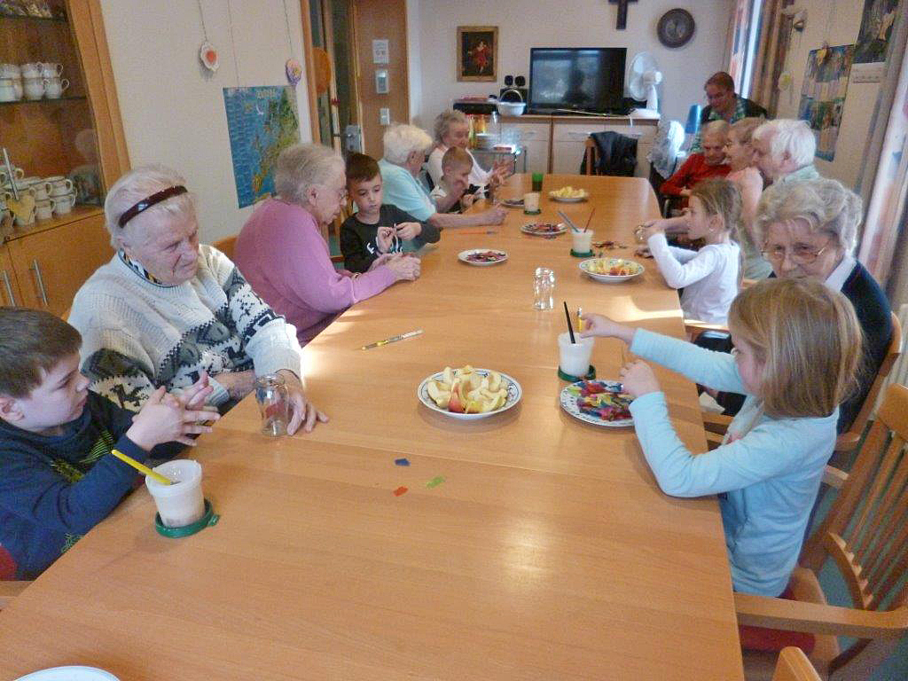 Kinder und Senioren sitzen am Tisch