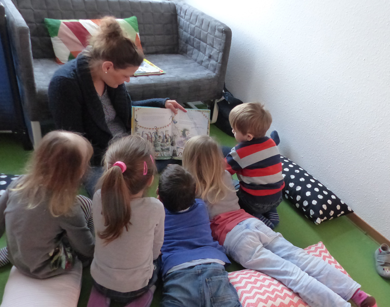 Die Kinder lauschen den vorgelesenen Geschichten